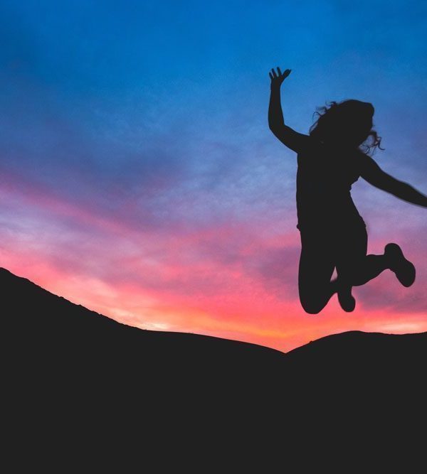 Silhouette of woman jumping to celebrate