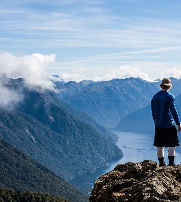 Man on ridge overlooking lakes and mountains